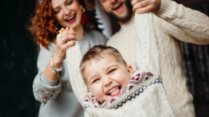 mãe e o pai brincando com o filho